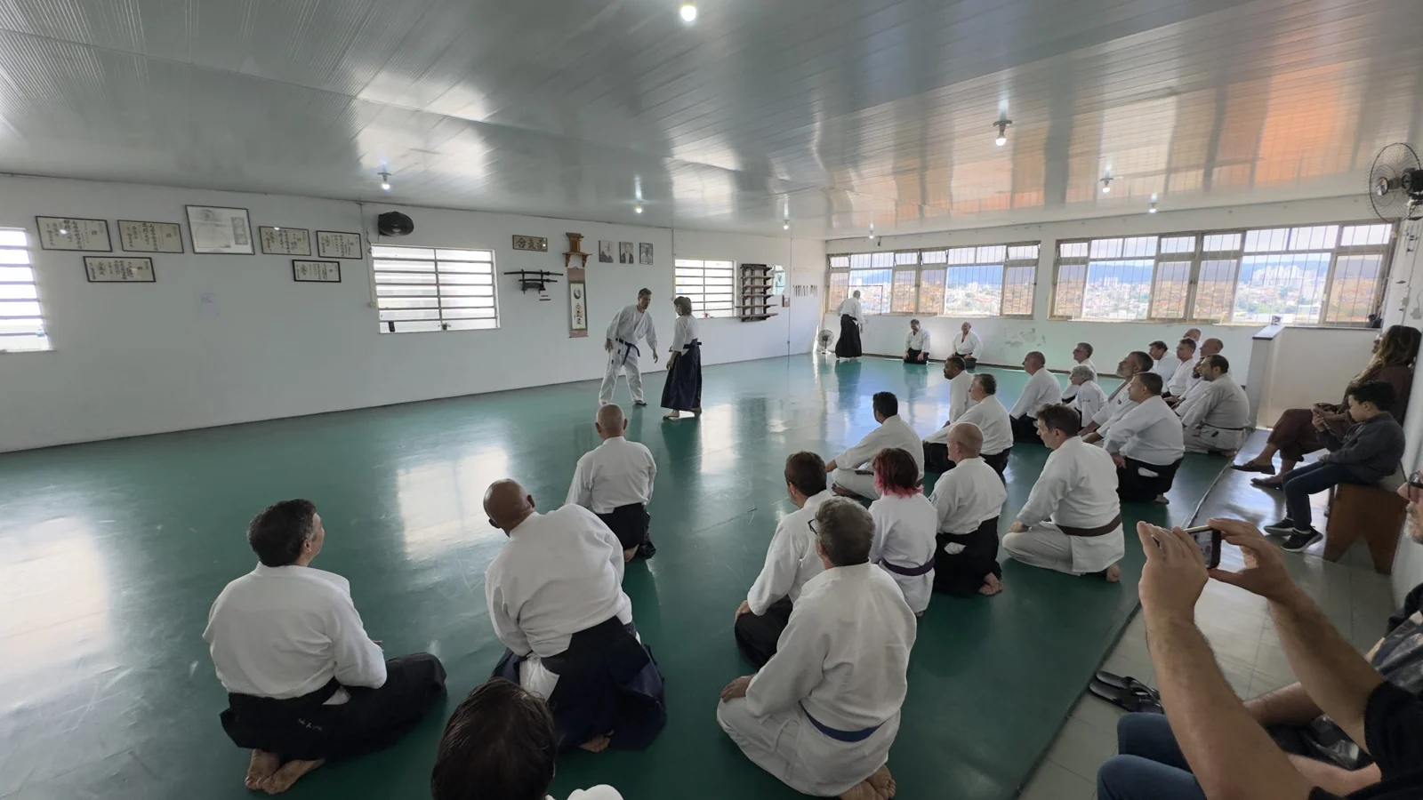 Praticantes atentos à orientação no dojo